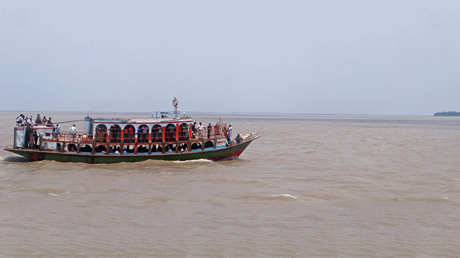 A small ferry carrying passengers across the Padma 