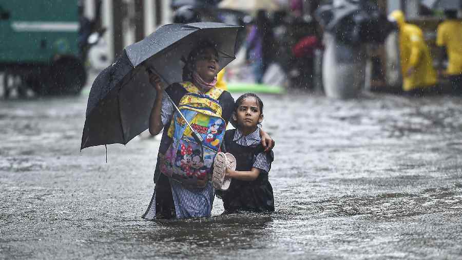  A school girl with her guardian amid rains