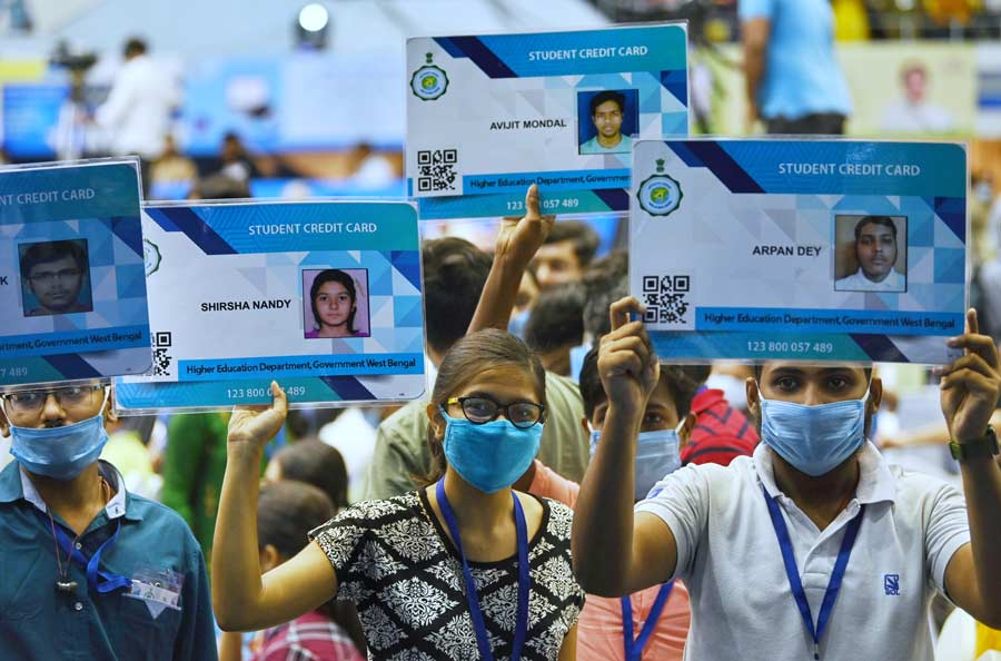 Students hold their state government-funded credit cards meant to be used for higher education at Netaji Indoor Stadium on Thursday, July 7. West Bengal chief minister Mamata Banerjee distributed the cards to the students Thursday afternoon.