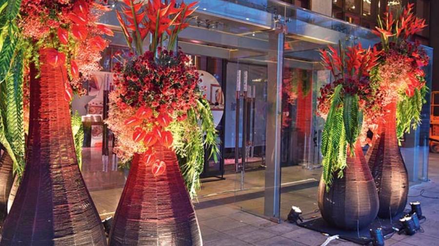 The entrance area was lined with celebratory floral elements such as these arrangements in cane and bamboo structures with red flowers and free-flowing leaves. This soft entry was a stark contrast to metallic stage setting.
