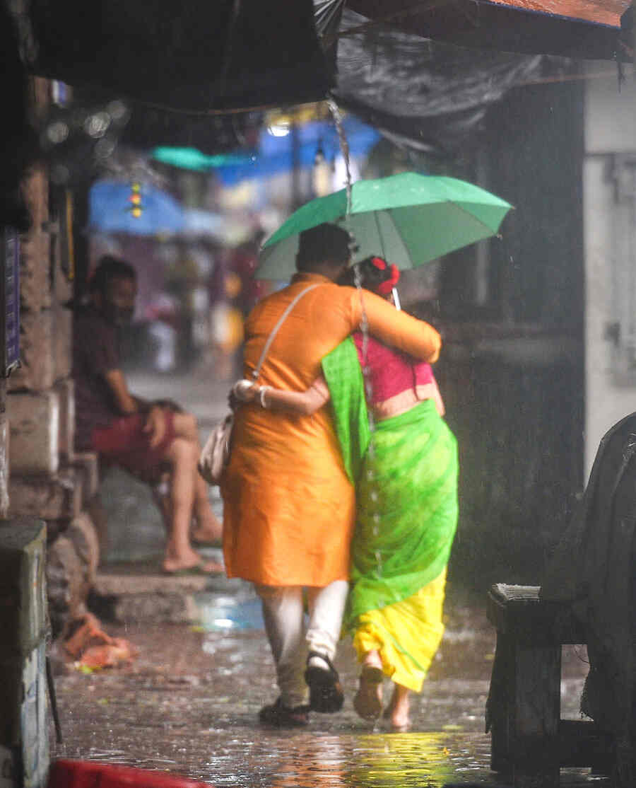 A man and a woman try to protect themselves from the rain on Monday.