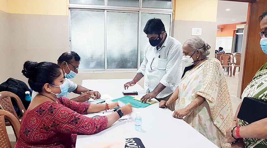 Residents getting themselves registered for their precautionary third dose of vaccine at BJ Block on Tuesday. Picture by Brinda Sarkar. (Right) A senior citizen gets jabbed at an NKDA vaccination centre on Wednesday.