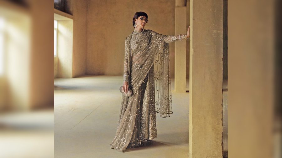 A hand-dyed tulle sari embellished with bevel beads, semi-precious stones, crystals and sequins, with an embroidered sequin blouse and jacket. Paired with statement jewellery from Sabyasachi High Jewellery’s Tropic of Calcutta and Heritage Collection and the craft edition of the Royal Bengal Minaudière by Sabyasachi Accessories.