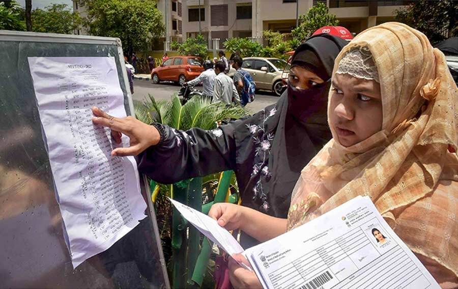 Students check the notice board for seating arrangements outside a NEET UG examination centre on Sunday. Medical aspirants across the country take the National Eligibility-cum-Entrance Test for admission to medical school every year.