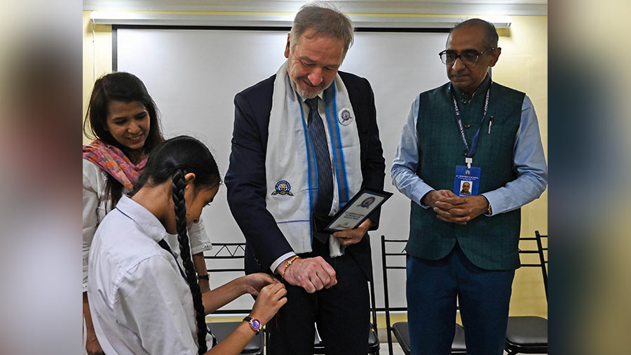 A student felicitates Adrian Pratt, acting US consul general and American Center director, as Imran Zaki, honorary secretary of St. Stephen’s School, Bowbazar, looks on. 
