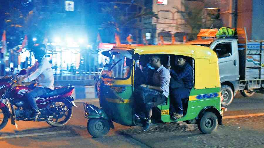 An autorickshaw with two passengers beside the driver on VIP Road on Tuesday evening. 