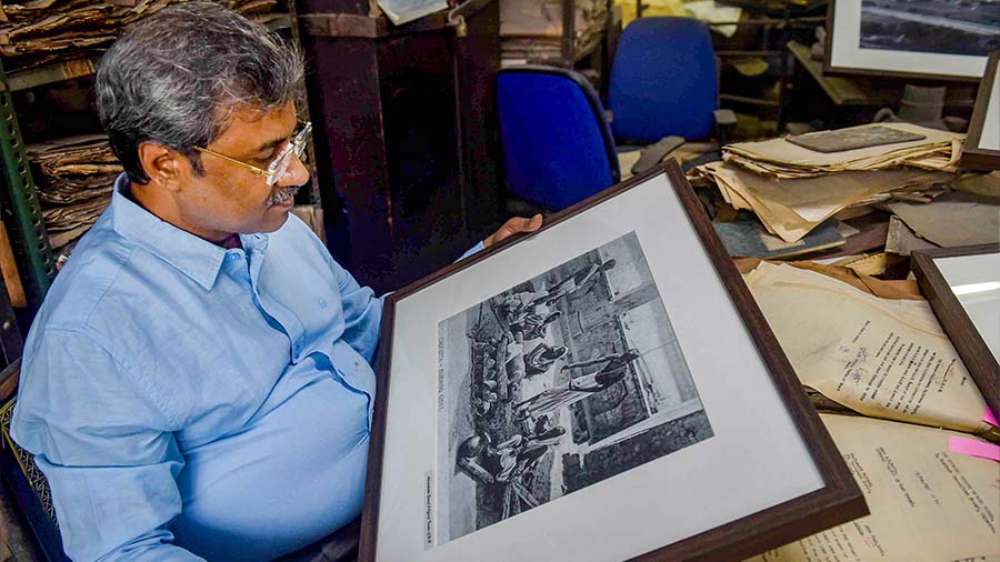 Biplab Roy shows old black-and-white photographs discovered in the storeroom
