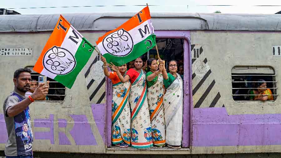 Female supporters of Trinamul Congress (TMC) wave party flags as they board a Sealdah bound train to participate in the partys Martyrs Day rally in Kolkata, in Nadia