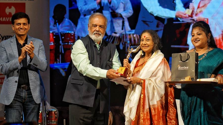 Ratna Ghoshal receives the Lifetime Achievement Award from Peerless Hospital managing director Sujit Kar Purkayastha.