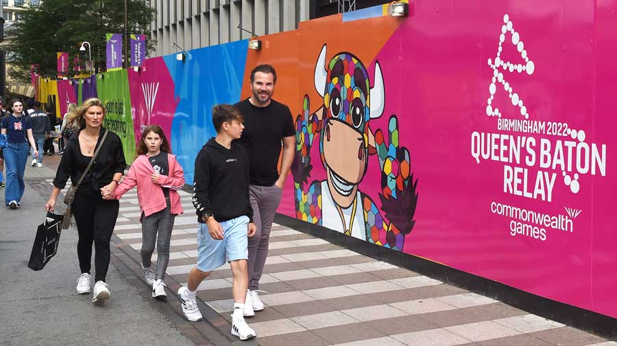 Locals walk past wall hoarding displaying Perry the Bull 