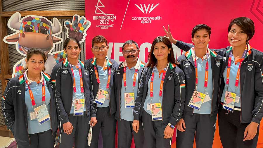 Boxers Lovlina Borgohain, Nikhat Zareen, Jasmine Lamboria and Nitu Ghanghas along with their coaches pose with Perry the Bull, the mascot of the game