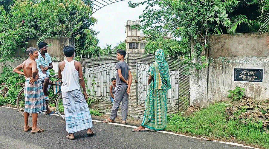 Villagers stand in front of the farmhouse in Baruipur, which is linked to former minister Partha Chatterjee, and was reportedly broken into around 1am  on Thursday.