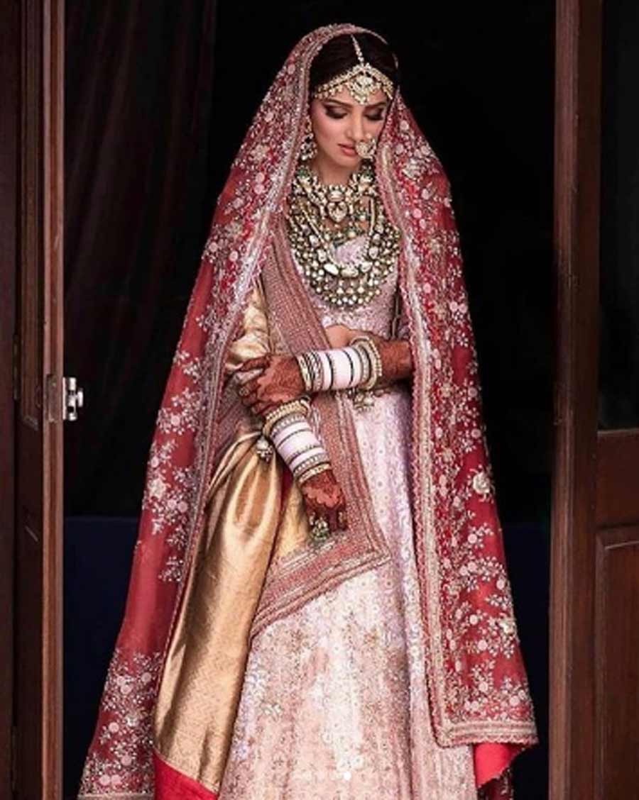 Dramatic bridal dupattas: The easiest way to wear white for a traditional desi wedding is to pair it with a vibrant zardosi veil. For her wedding to Rana Daggubati, Miheeka Bajaj went for a subtle, white chikankari lehenga by Anamika Khanna and styled it with a heavier red veil and another woven gold dupatta to add a metallic accent 