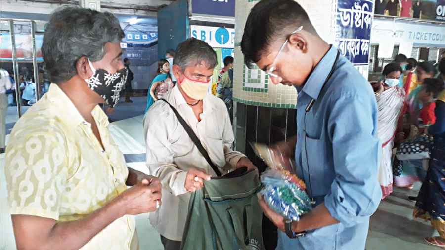 A visually impaired hawker sells pens made of paper at Dum Dum railway station