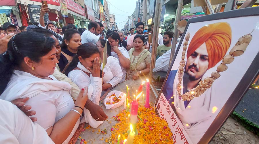 Congress workers light candles and pay floral tribute to late Punjabi singer and Congress leader Sidhu Moose Wala, who was shot dead on Sunday, at Sadbhawna Chowk in Bathinda