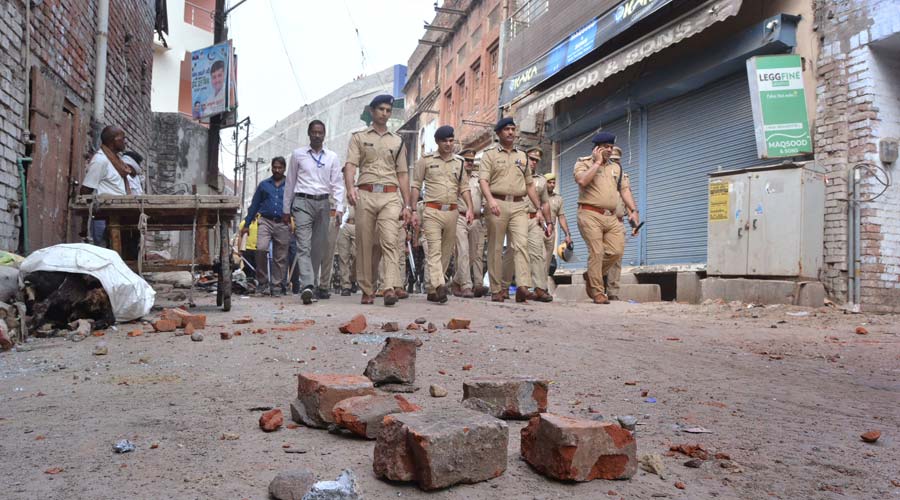 Police conduct flag march in a locality, a day after clashes broke out between two groups over market shutdown, in Kanpur on Saturday.