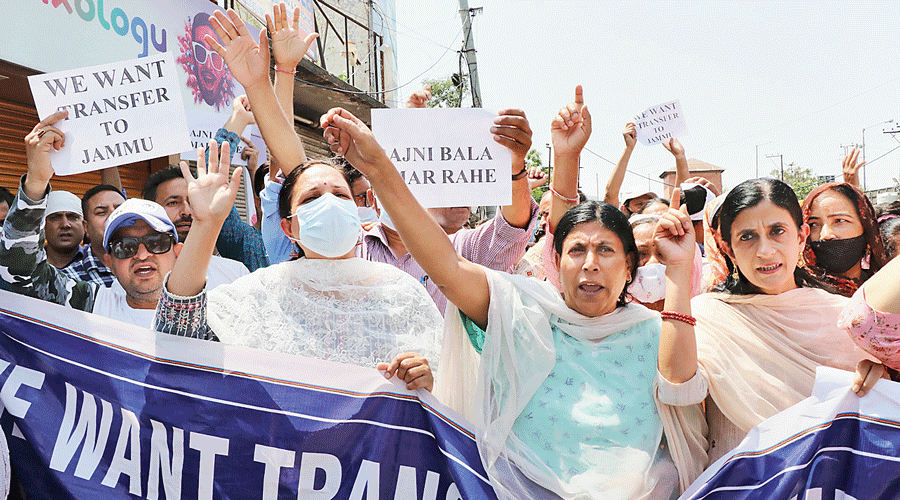 Jammu-based government employees who have fled their postings in Kashmir agitate in Jammu on Saturday, demanding transfers to their home districts.