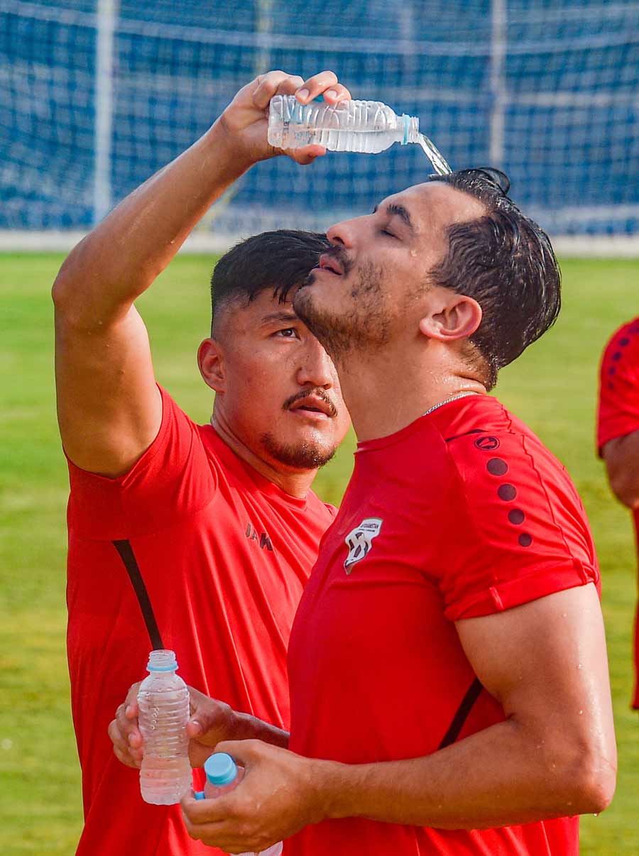 An Afghanistan football player seeks relief from the hot and sultry weather during practice at Salt Lake Stadium on Tuesday.