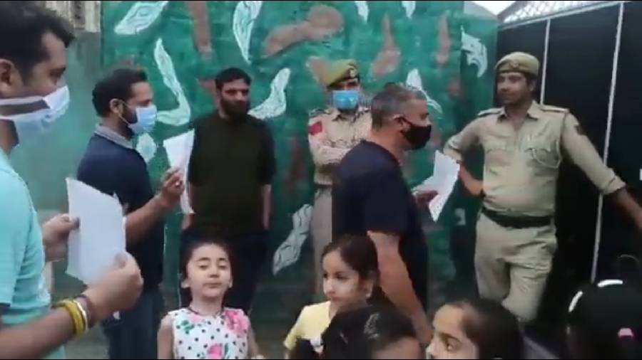 Screen grab from a video shared on Twitter, that shows Kashmiri Pandits along with kids staging a demonstration today.