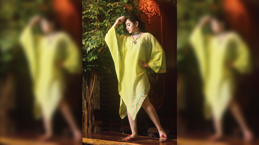 Ideal for a day look or a brunch, this smart and simple lime green handkerchief-style kaftan from Aranya is given a stylish touch with dark green hue on the eyes, complemented with brown lips and side-parted messy pony.