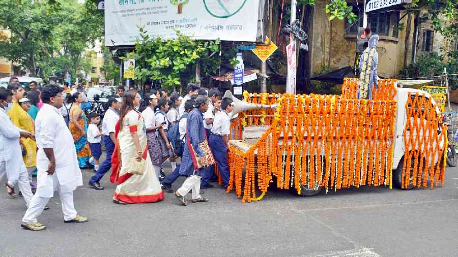 Students and teachers of Rammohan Mission High School walk the street alongside a tableau to mark the 250th birth anniversary of Raja Rammohan Roy