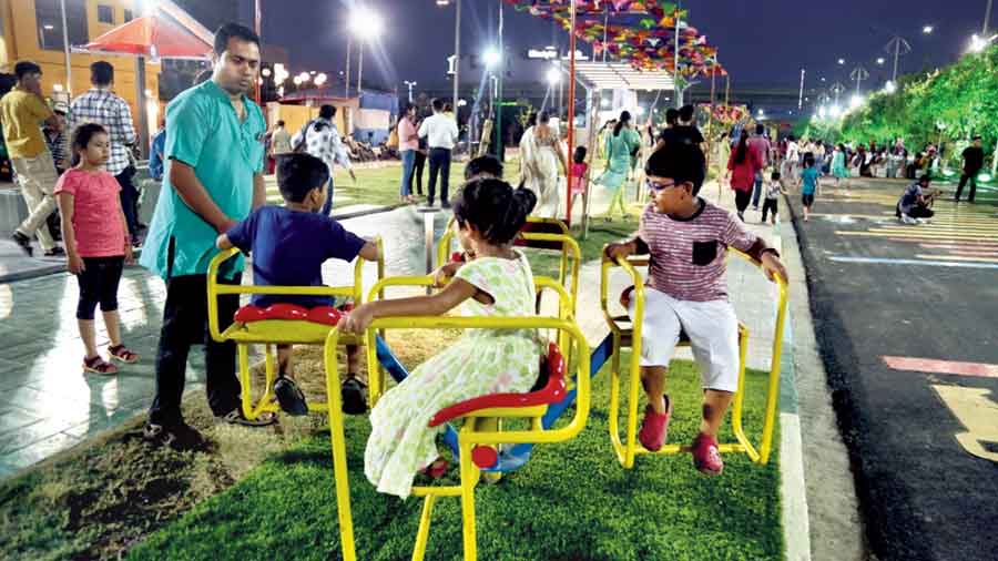 Children enjoy a ride on a merry-go-round installed on the pavement