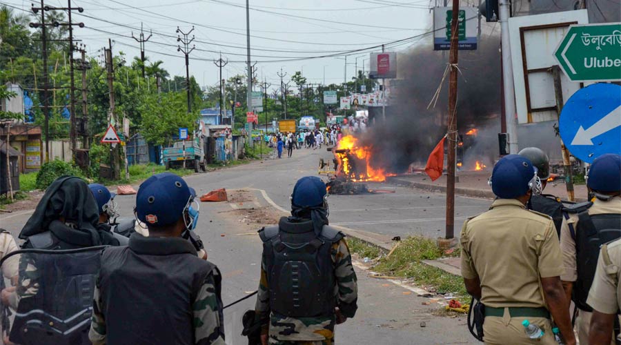 Security personnel try to maintain law and order as a vehicle is allegedly set ablaze by miscreants during a protest over controversial remarks made by two now-suspended BJP leaders about Prophet Mohammad, in Howrah on Friday.