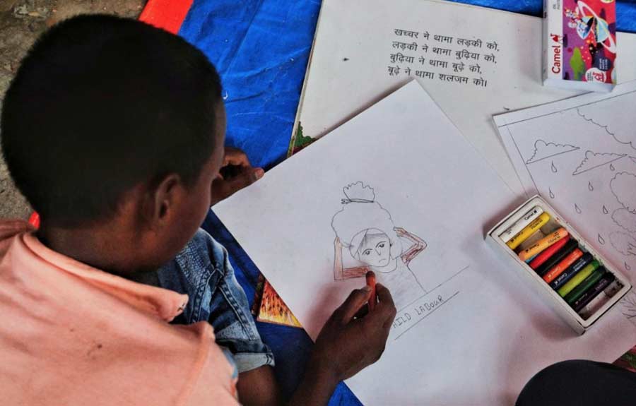 A child draws a picture at an event held to mark World Day Against Child Labour at Harijan Gyanmandir School in Taratala of central Kolkata.