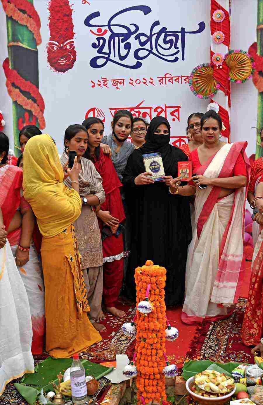 Women hold a Quran and a Bhagavad Gita at a ceremony marking the beginning of Durga Puja preparations. The event included women from the Muslim community as a gesture of religious harmony 