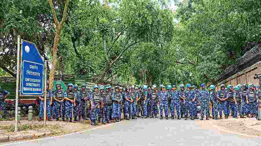 The Rapid Action Force stands guard outside the Enforcement Directorate office in New Delhi on Monday. 