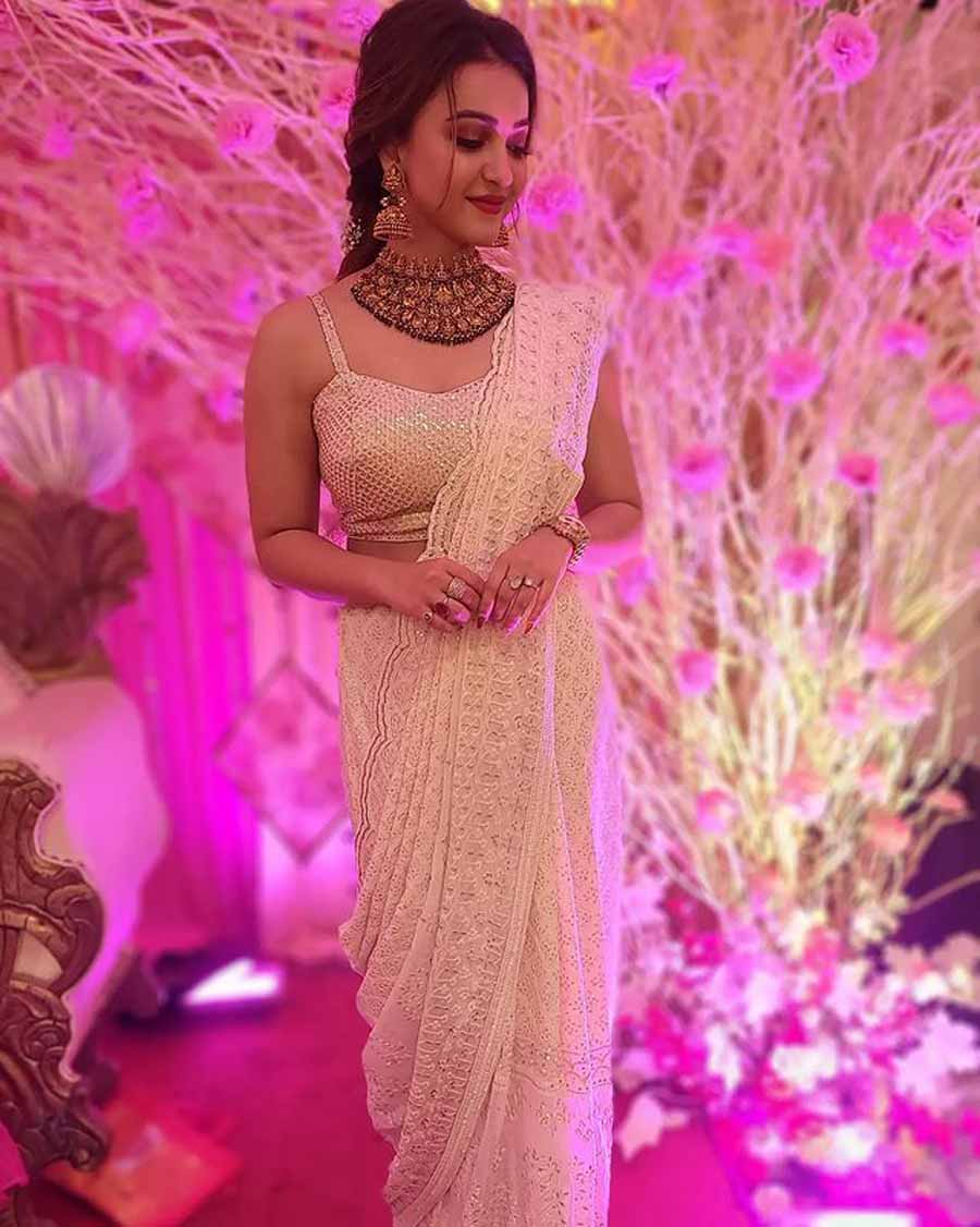 Koushani Mukherjee: All white and chikankari? Sign us up! Koushani sported this elegant look at her sister’s wedding and looks gorgeous. The draping of the sari makes all the difference while the minimalistic makeup and braid brings the whole ensemble together. 
