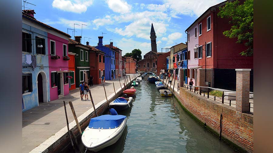 A view of the canal-lined streets of Burano with the tower of San Martino church far ahead