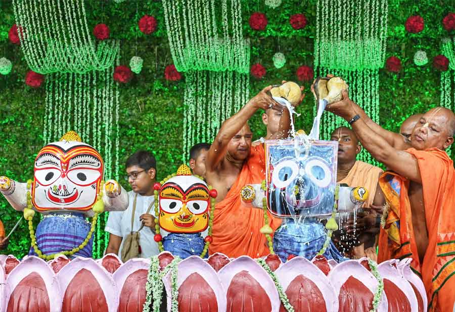 Priests perform the bathing ritual of Jagannath-Balaram-Subhadra at the ISKCON temple on Gurusaday Dutta Road on Tuesday.