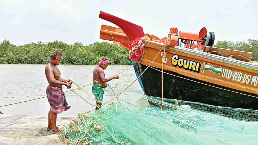 Hilsa fishermen with their trawler in Fraserganj of South  24-Parganas on Tuesday. 