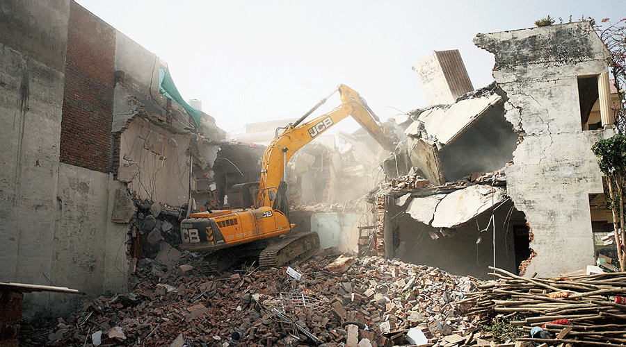 A bulldozer demolishes the allegedly illegal part of the house of Javed Mohammad, who was accused in last week’s violence, in Allahabad on June 12.
