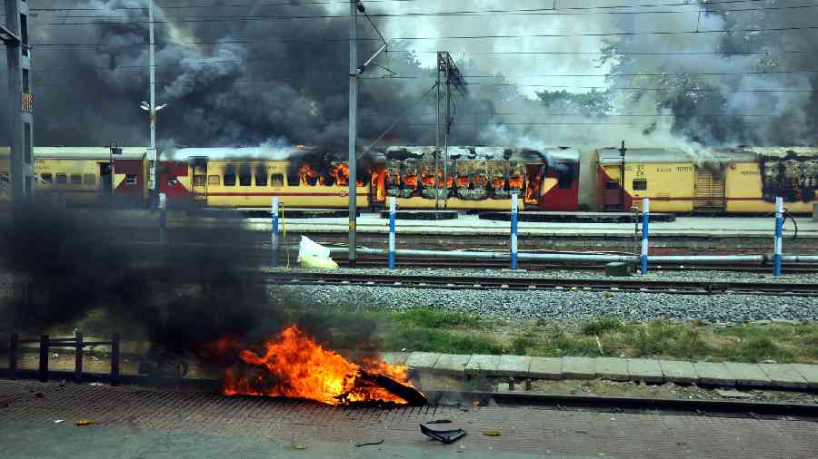 Train set on fire by a crowd in protest against the Centres Agnipath scheme