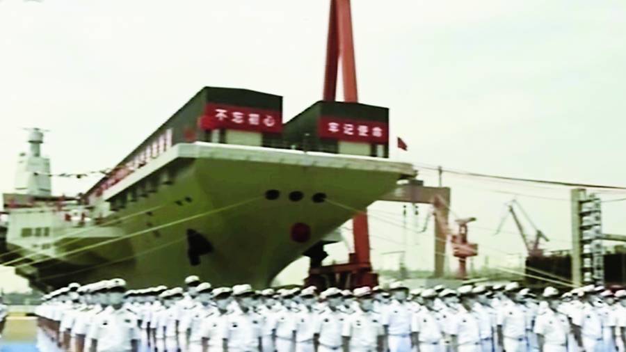 A picture taken from CCTV video footage shows sailors in front of China’s third aircraft carrier, christened Fujian, before its launch