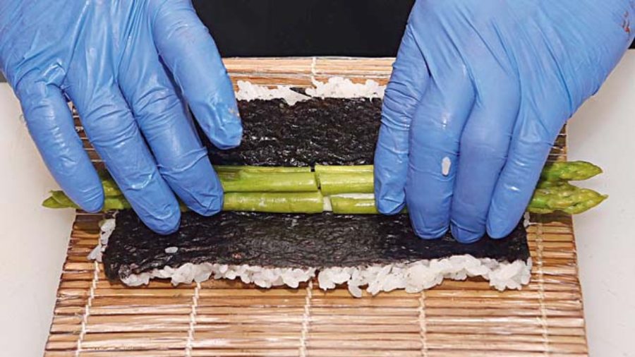 Asparagus Tempura Maki being rolled.