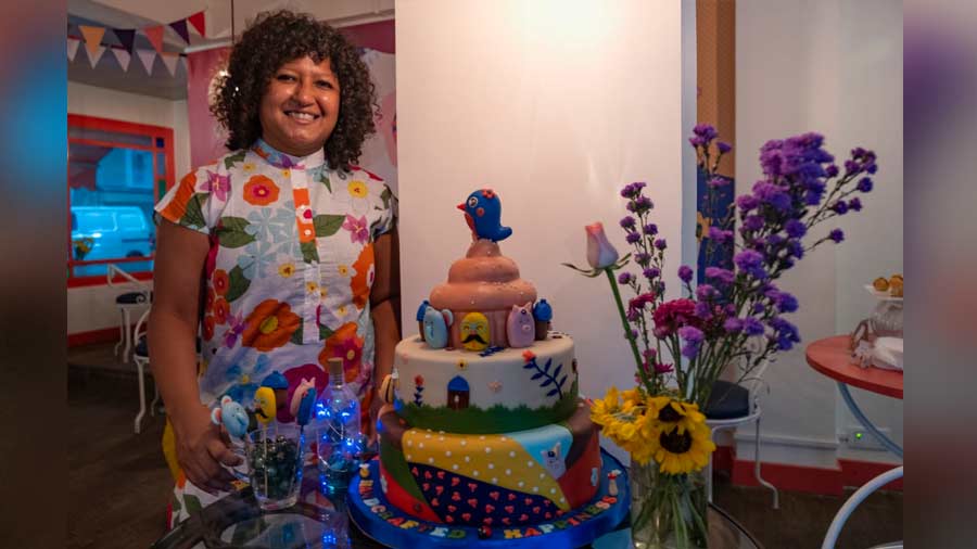 Sohini Basu poses near a decadent tiered cake at Mrs. Magpie 