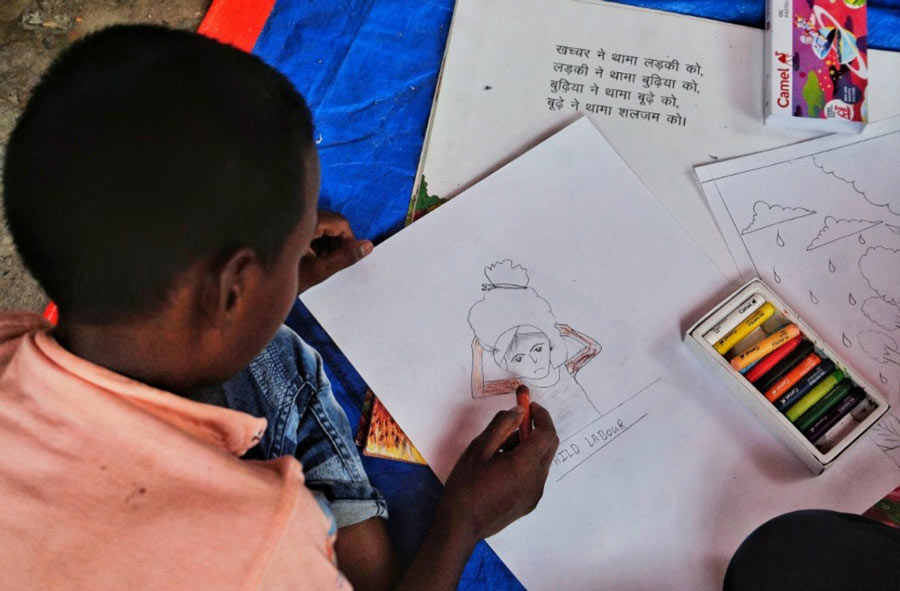 A child draws a picture at an event held to mark World Day Against Child Labour at Harijan Gyanmandir School in Taratala of central Kolkata on Monday, June 13.