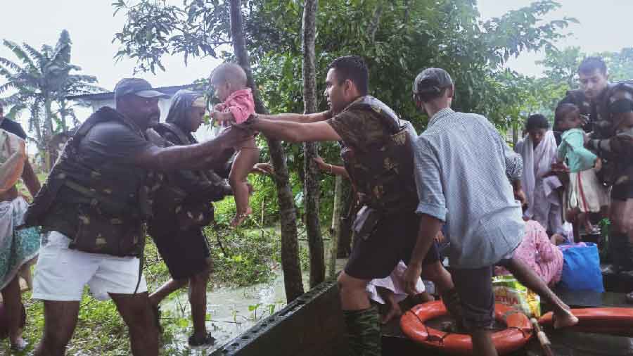 Rescue workers by hapless people's sides in a flood-ravaged Assam
