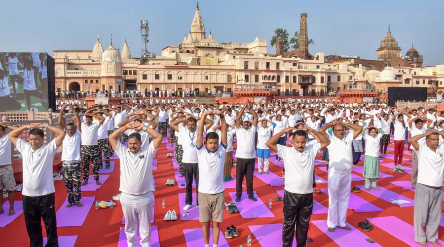 People attend a mass yoga session at Ram Ki Pouri to celebrate the 8th International Day of Yoga, in Ayodhya