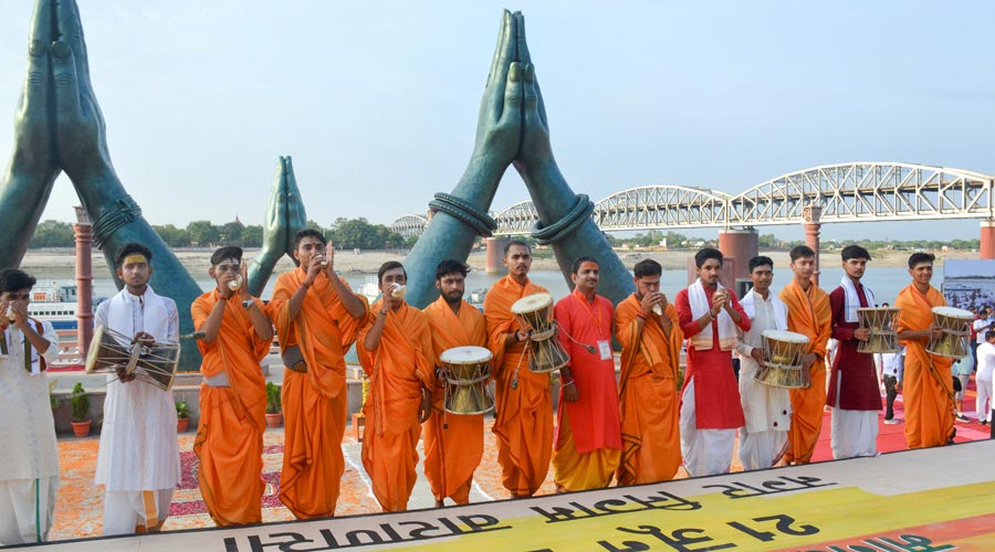 Priests perform prayers before the start of a yoga session at Khidkiya Ghat in Varanasi