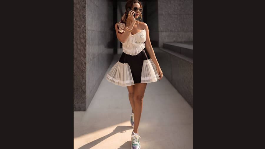 Malaika Arora’s cute plisse skater dress in earthy tones teamed with comfy sneakers is perfect for lunch dates or brunch meet-ups.