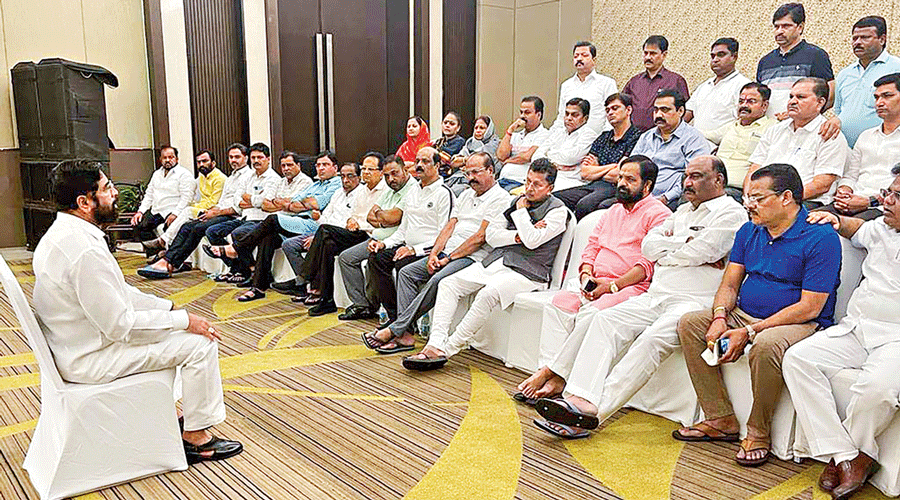Rebel Shiv Sena leader Eknath Shinde interacts with MLAs supporting him, at a hotel in Guwahati on Thursday.
