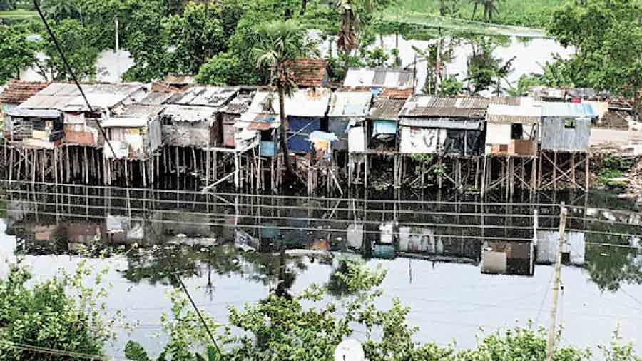 Huts on concrete and bamboo stilts along Bagjola canal