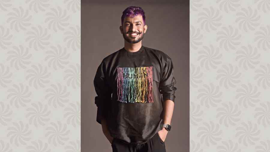 Rahul has chosen a drop-shouldered silk Chanderi layered shirt with rainbow-dyed shibori cord detailed typography, teamed with pleated trousers.