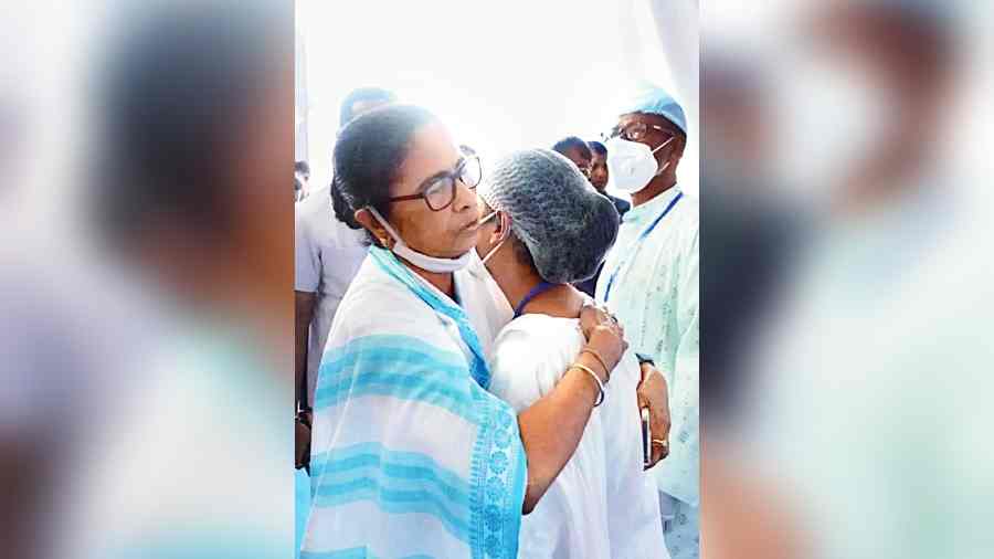 Chief minister Mamata Banerjee hugs nurse Renu Khatun whose husband allegedly chopped off her right palm recently to prevent her from taking  up a government job.