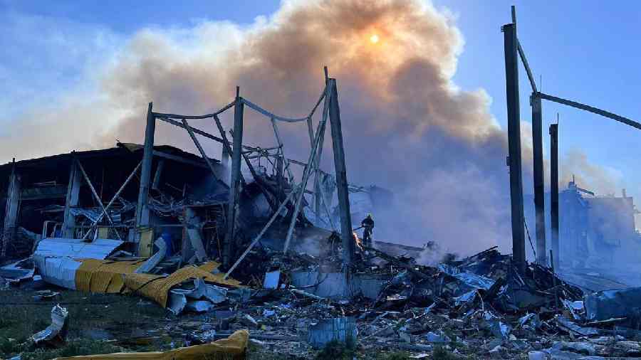 Rescuers help firefighters after the shopping mall in Kremenchuk, Poltava regionof Ukraine, was hit by a Russian missile strike on Monday. 