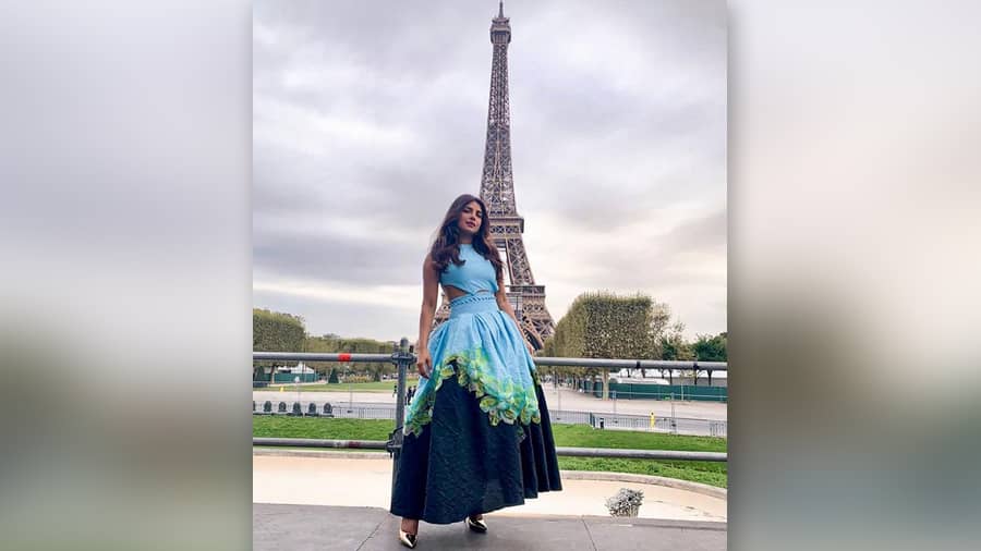 “An Evening in Paris” in front of Eiffel Tower as the fashionista sports a layered Prabal Gurug outfit. 